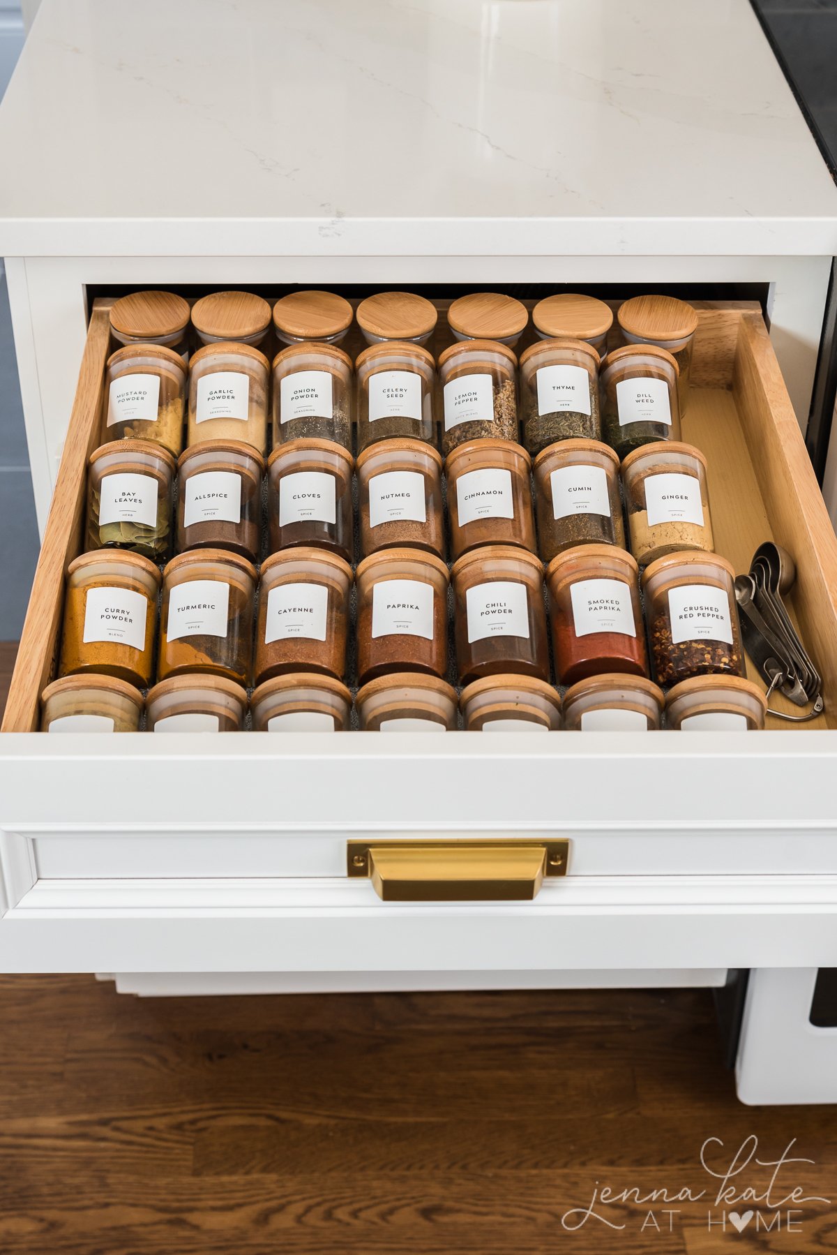 organized spice jars with custom labels inside a drawer