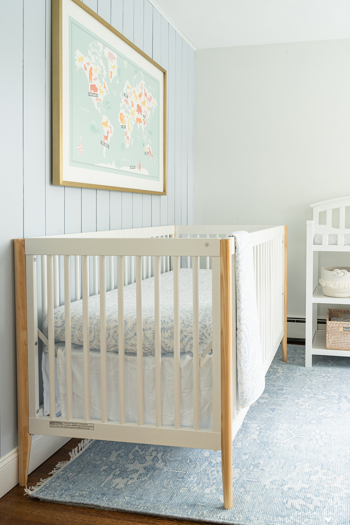 crib with artwork on the shiplap wall