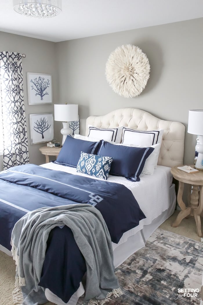 blue and white bedroom decor with white juju hat on wall above bed