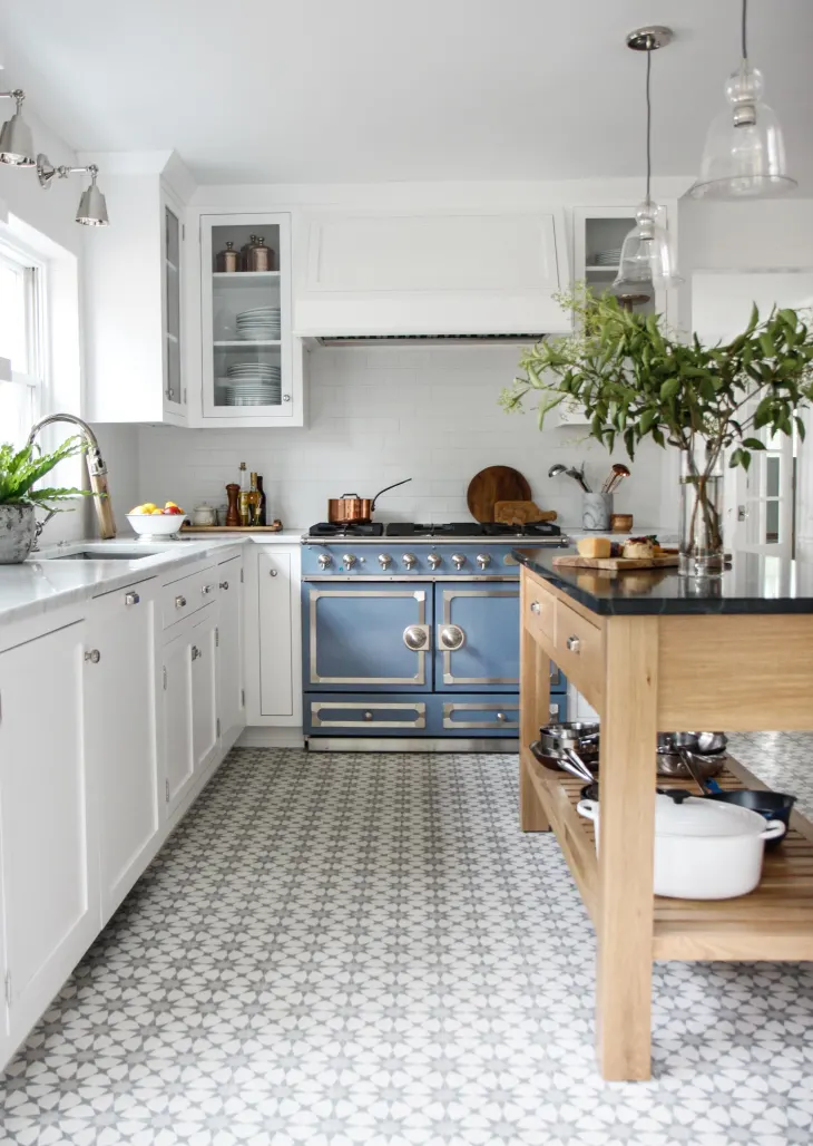 decorator's white kitchen cabinets with blue range and chrome hardware