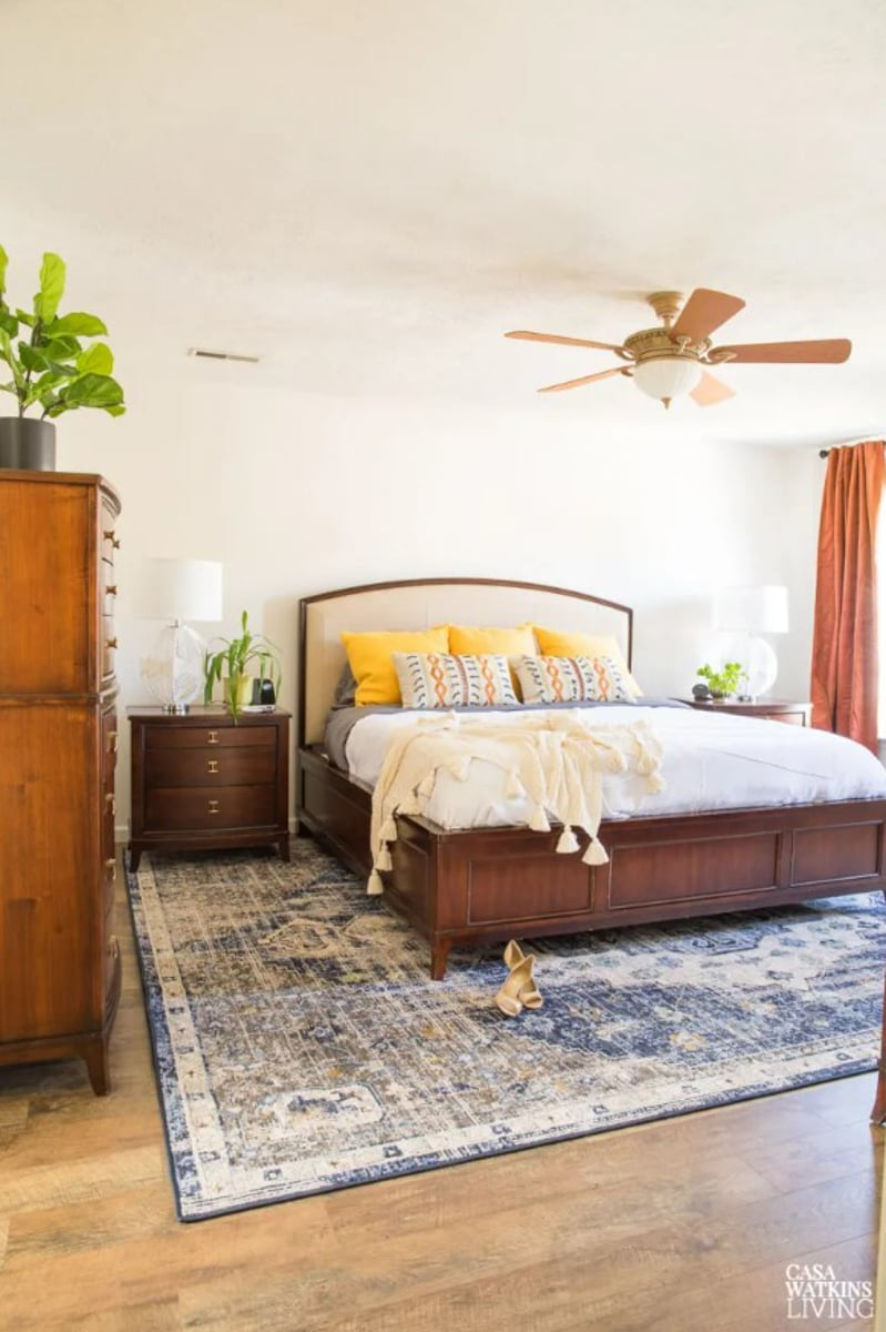 neutral bedroom with dark wood bed, white walls and earthy colors