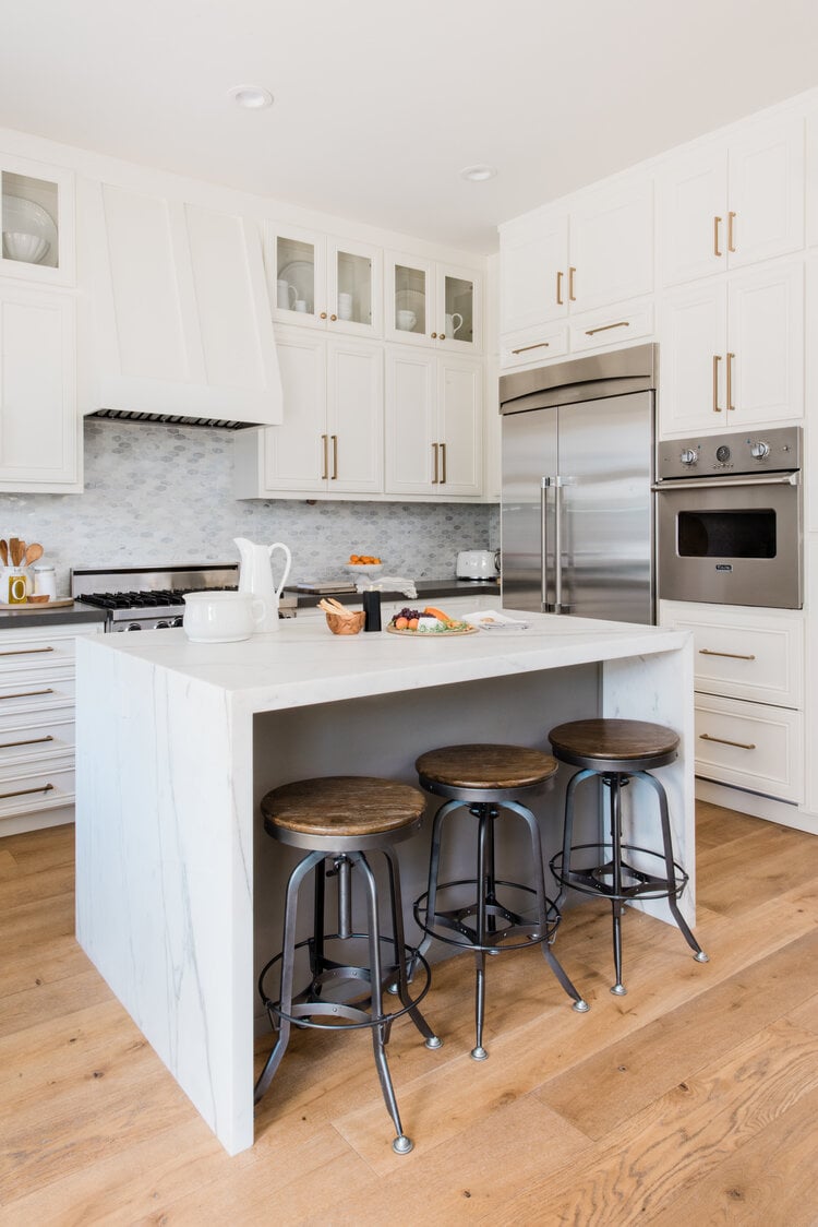 Swiss coffee kitchen cabinets with brass hardware and marble island