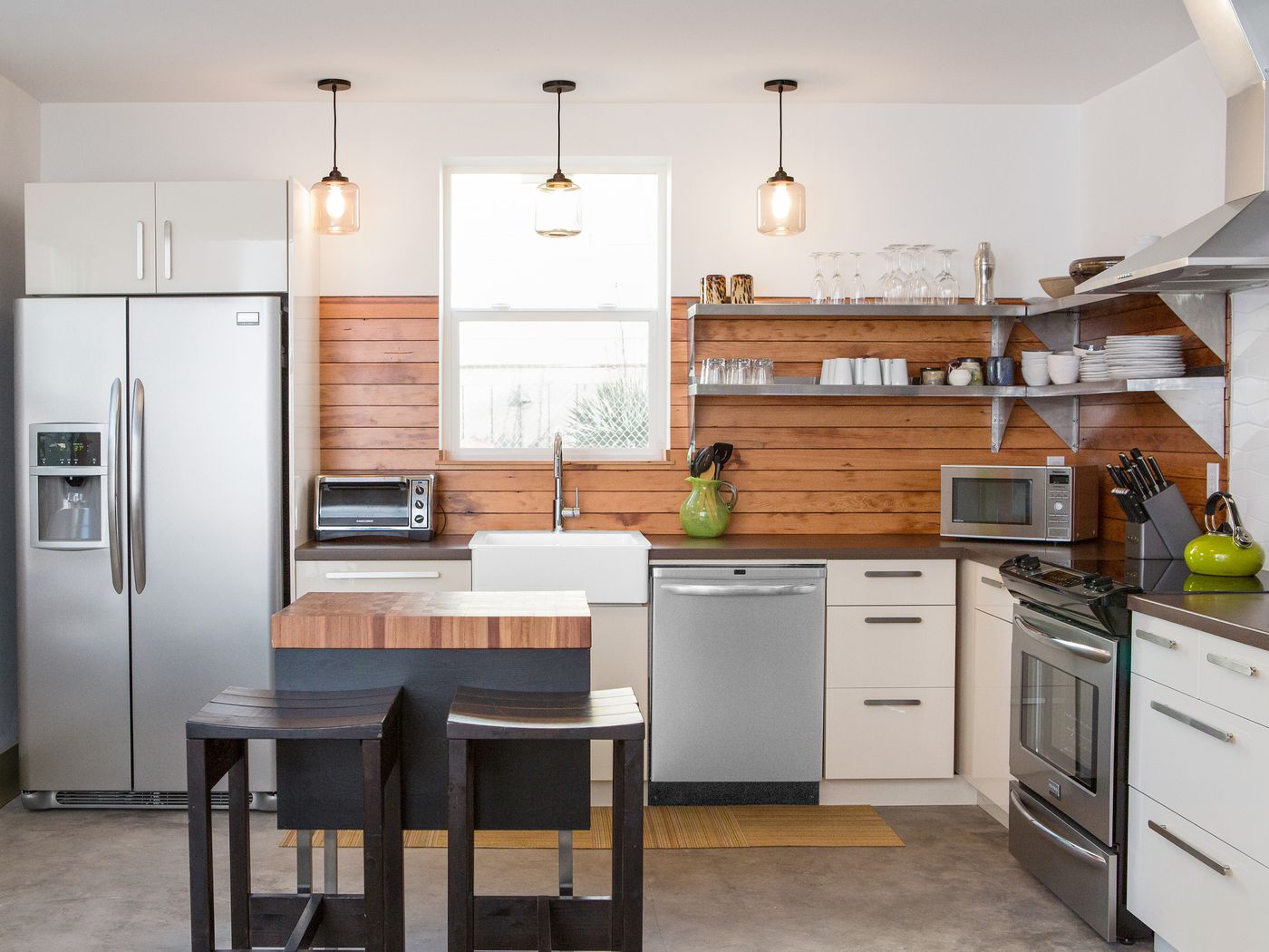 wooden kitchen backsplash, white cabinets, window, stainless steel appliances