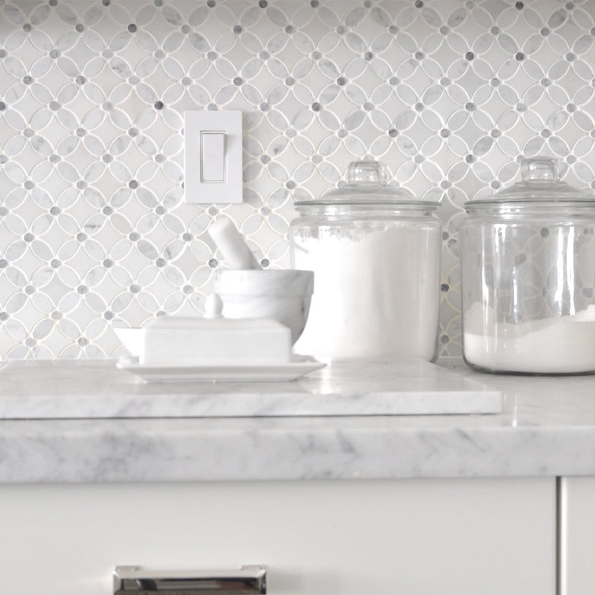 Marble Flower patterned tile on kitchen backsplash with white cabinets.