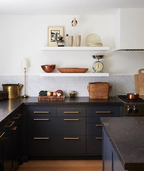 kitchen with black lower cabinets and white floating shelves