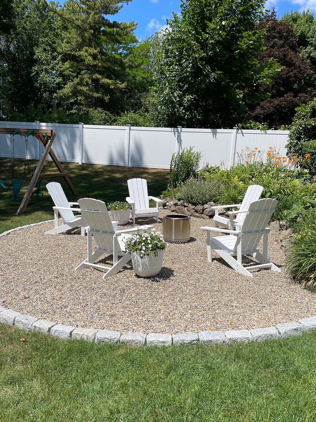 outdoor firepit with white chairs in backyard
