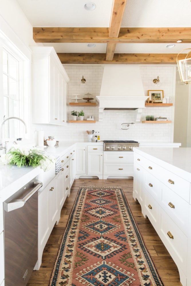 white dove kitchen cabinets with rustic beams overhead.
