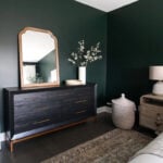 A bedroom with Benjamin Moore Essex Green walls and a dresser.