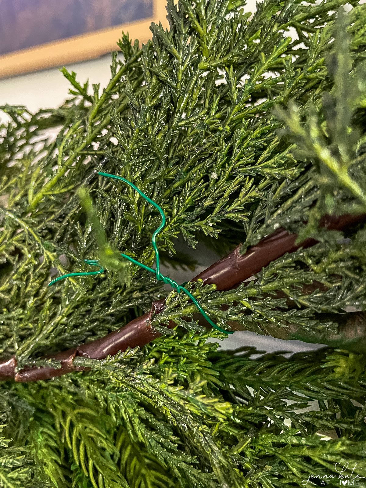 green floral wire securing two pieces of garland together