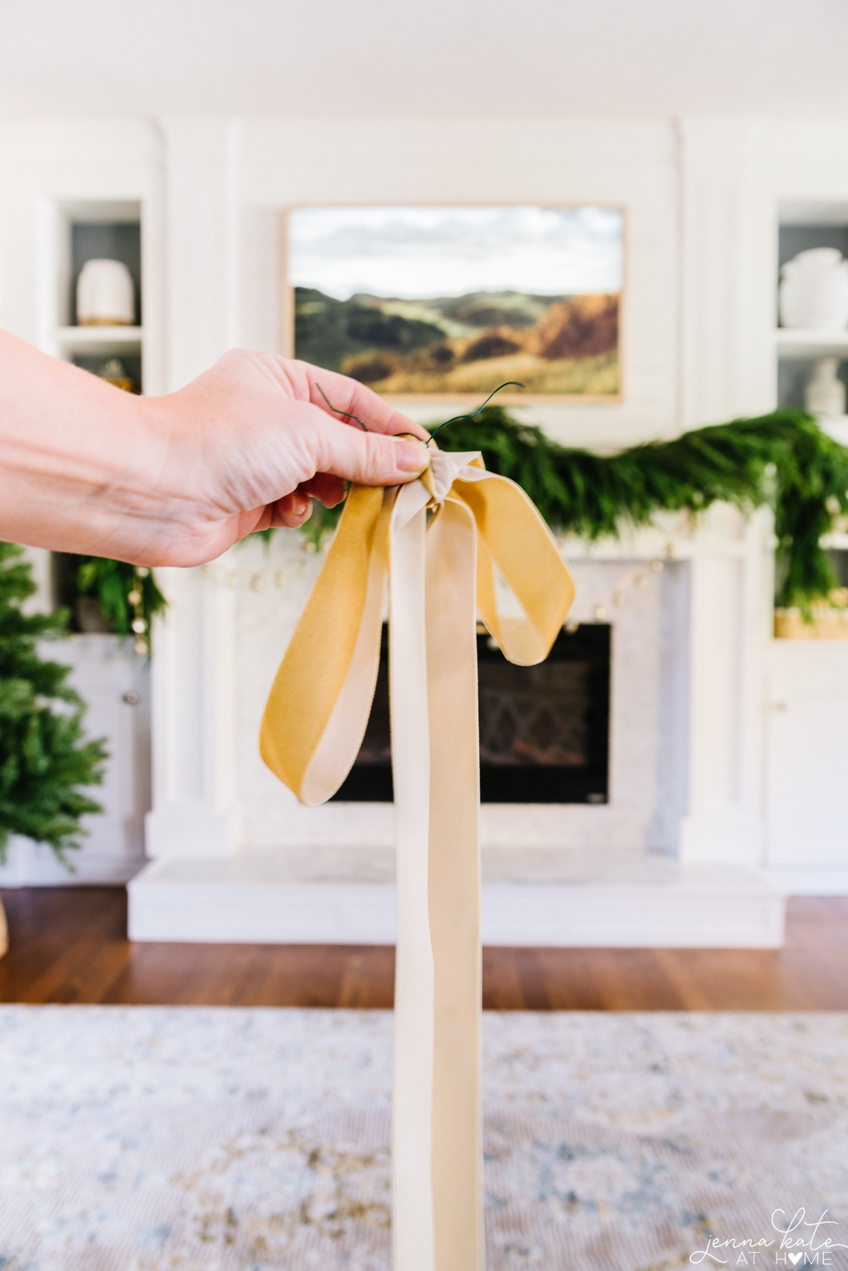 hand holding gold ribbon tied in a bow
