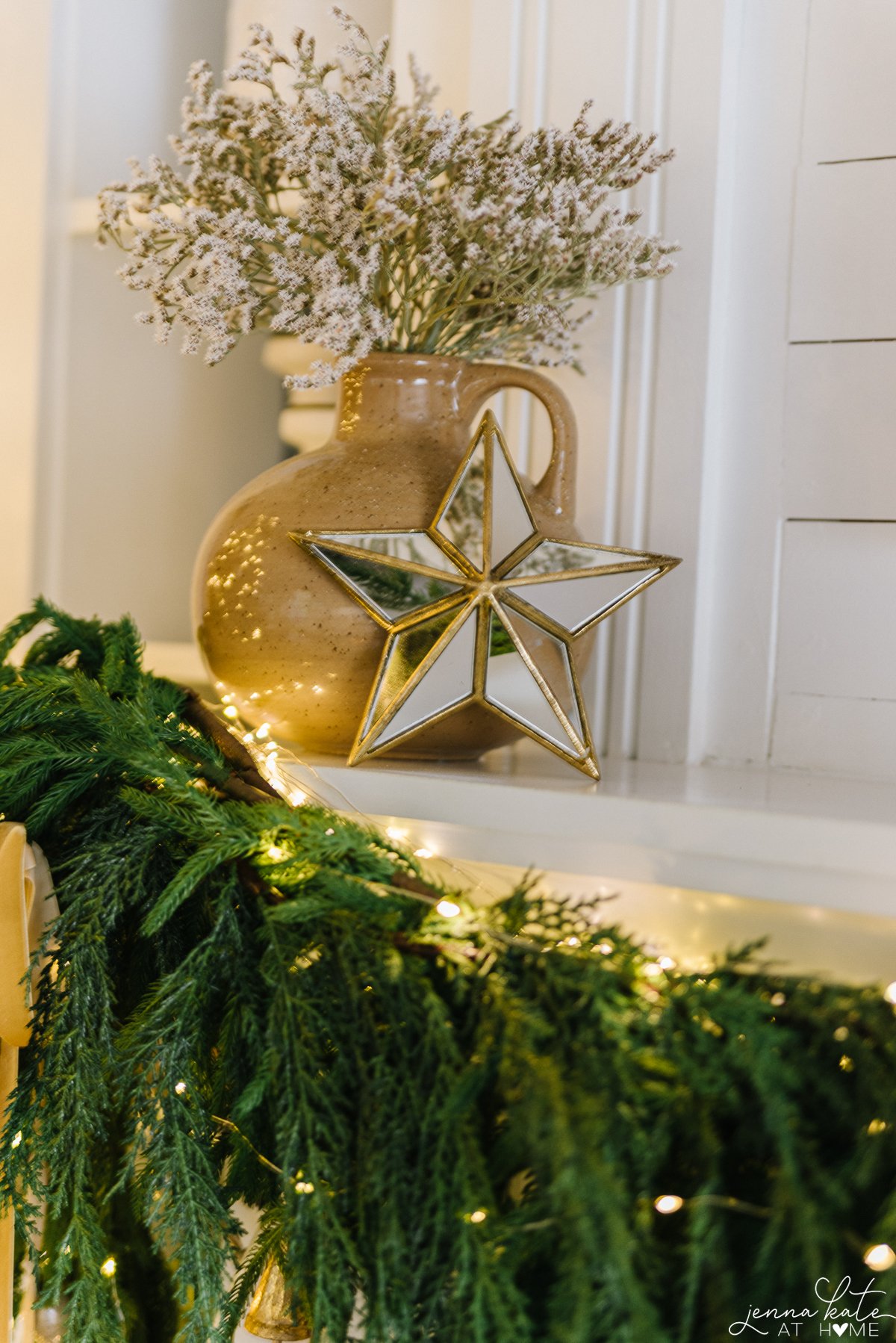 vase of dried flowers and a glass star on the mantel