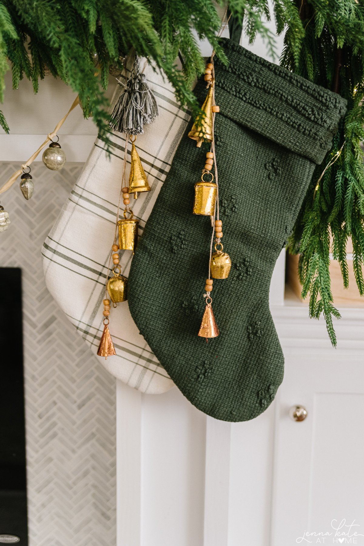 green and plaid christmas stockings with bell chimes hanging from them