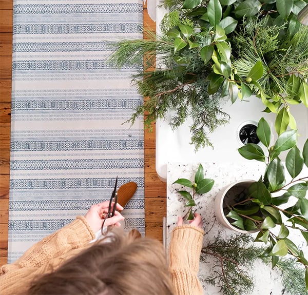 woman cutting houseplants with blue anti fatigue mat underfoot