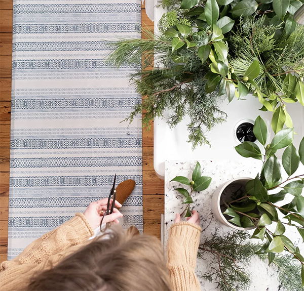 woman cutting houseplants with blue anti fatigue mat underfoot