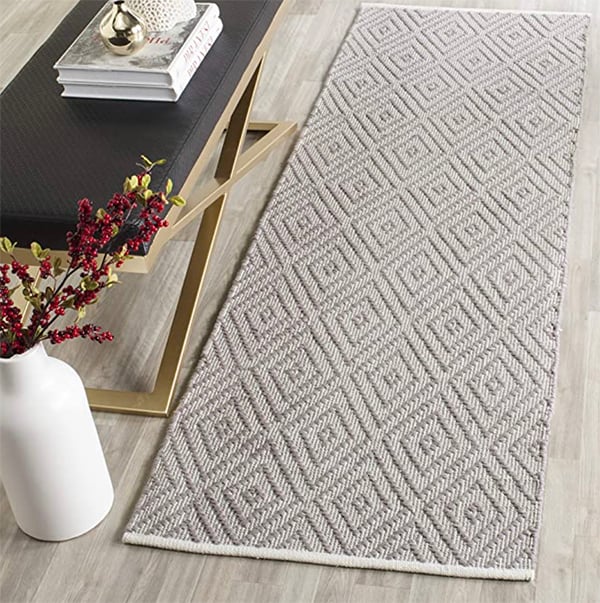 trellis pattern runner rug on hardwood floor next to a bench