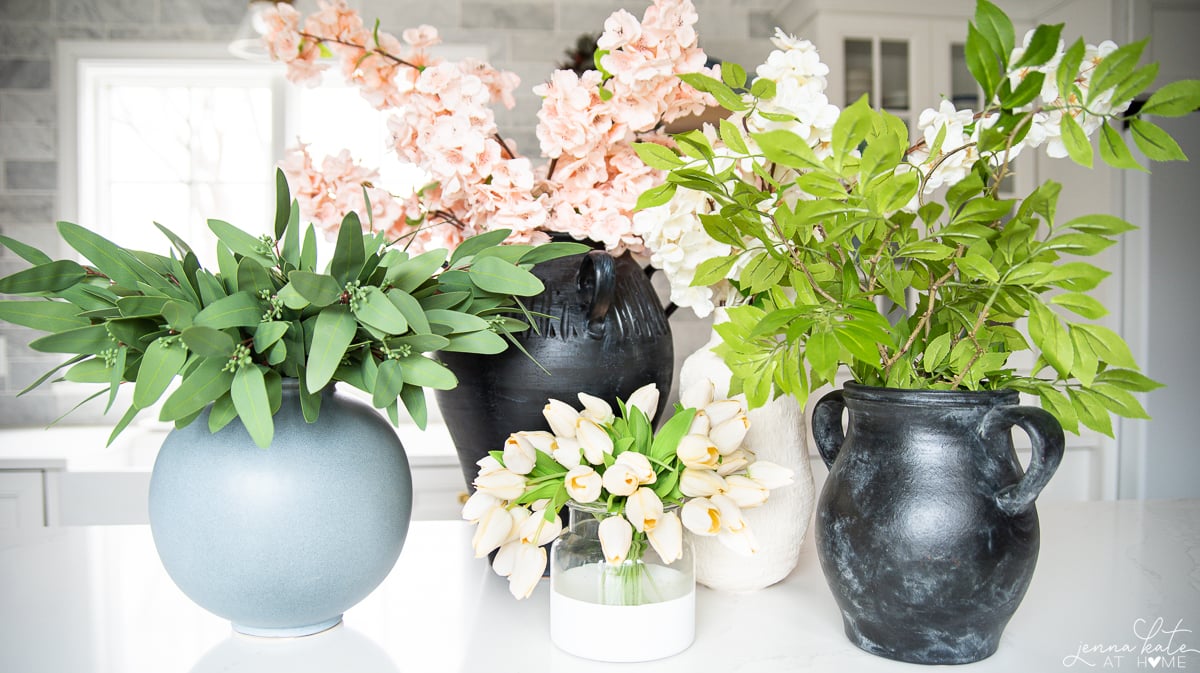 various artificial flowers and greenery on a kitchen island