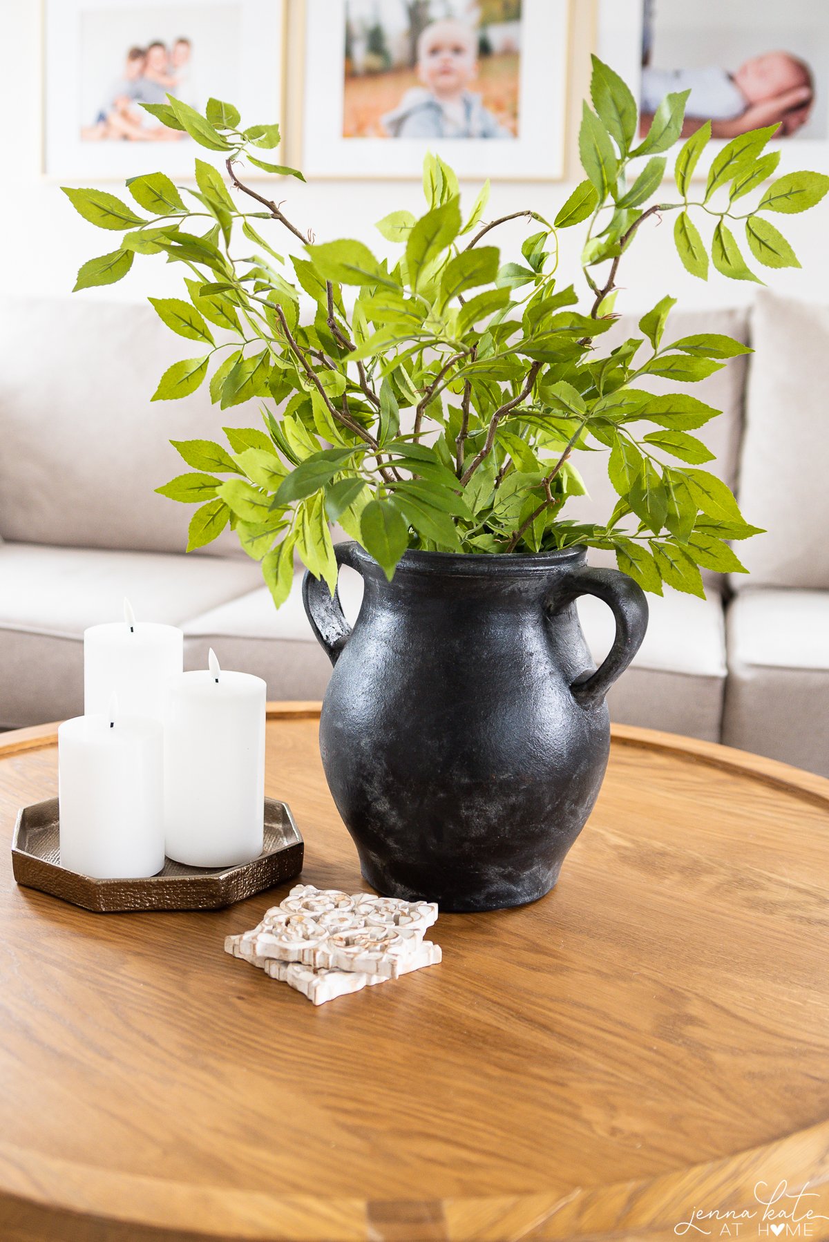 small black urn with leafy fake greenery