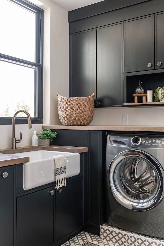 Beautiful laundry room with Black Panther painted cabinets with natural light