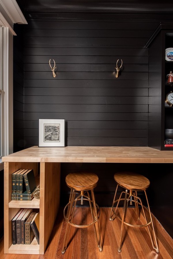 Moody room painted in Caviar with wood desk and stools.