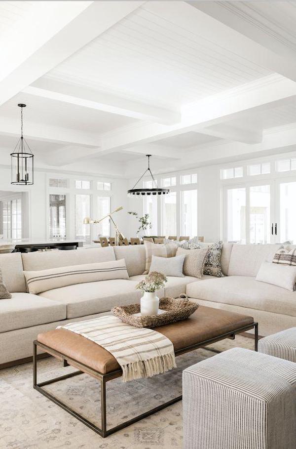 Open concept space converted to closed space with large sectional beige couch