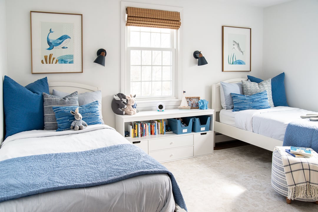 a little boys bedroom with two twin beds and a cubby in the middle.