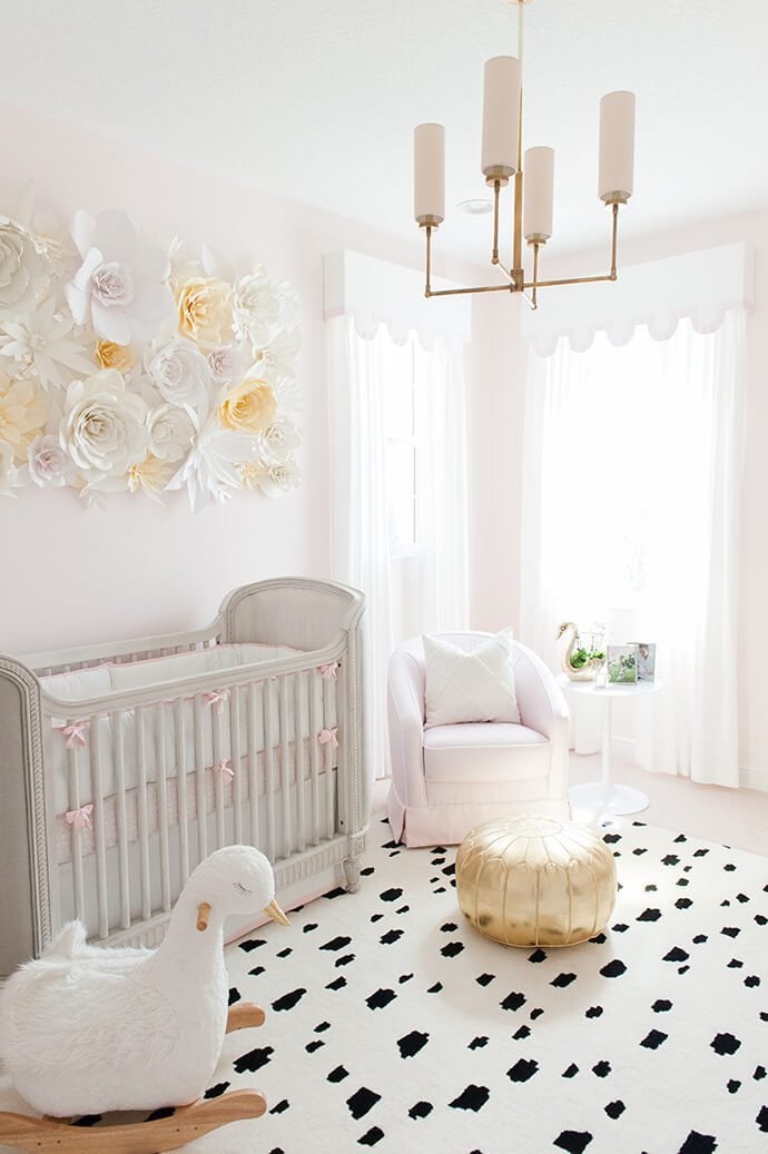 Pretty in pink nursery using Gentle Butterfly by Benjamin Moore on the walls and a fun modern black and white rug. 