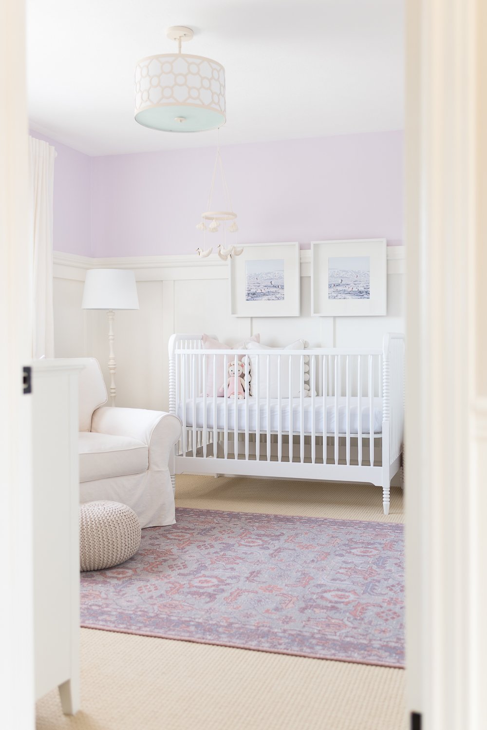 baby girl's nursery with Benjamin Moore Raspberry Ice paint color on the walls, white wainscoting and white furniture