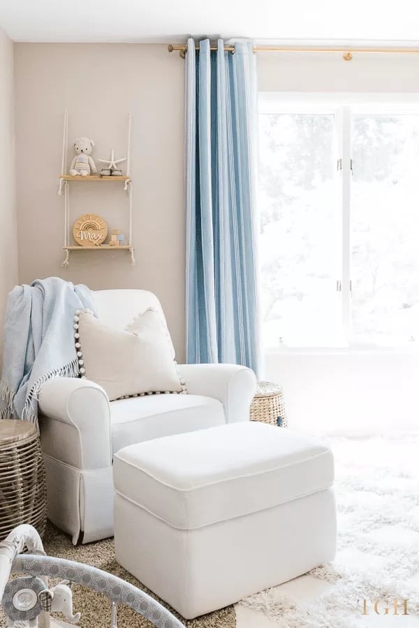 Baby boy nursery with Benjamin Moore Big Bend Beige on the walls, blue curtains and white rocker