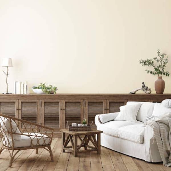 Light and airy living room with Dover White walls, a comfy couch, and long wooden console. 