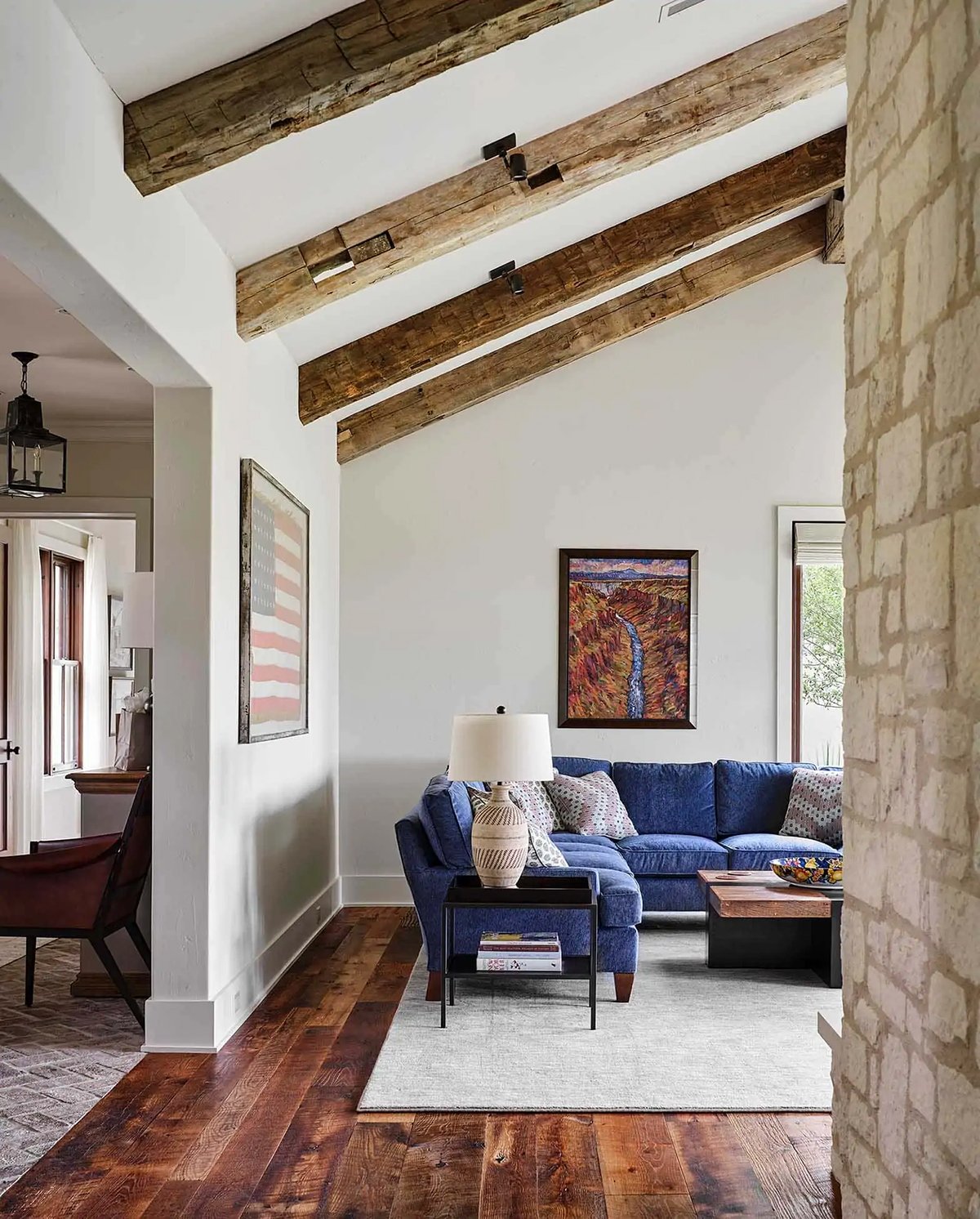 BM Winds breath living room walls with navy couch and rustic ceiling beams