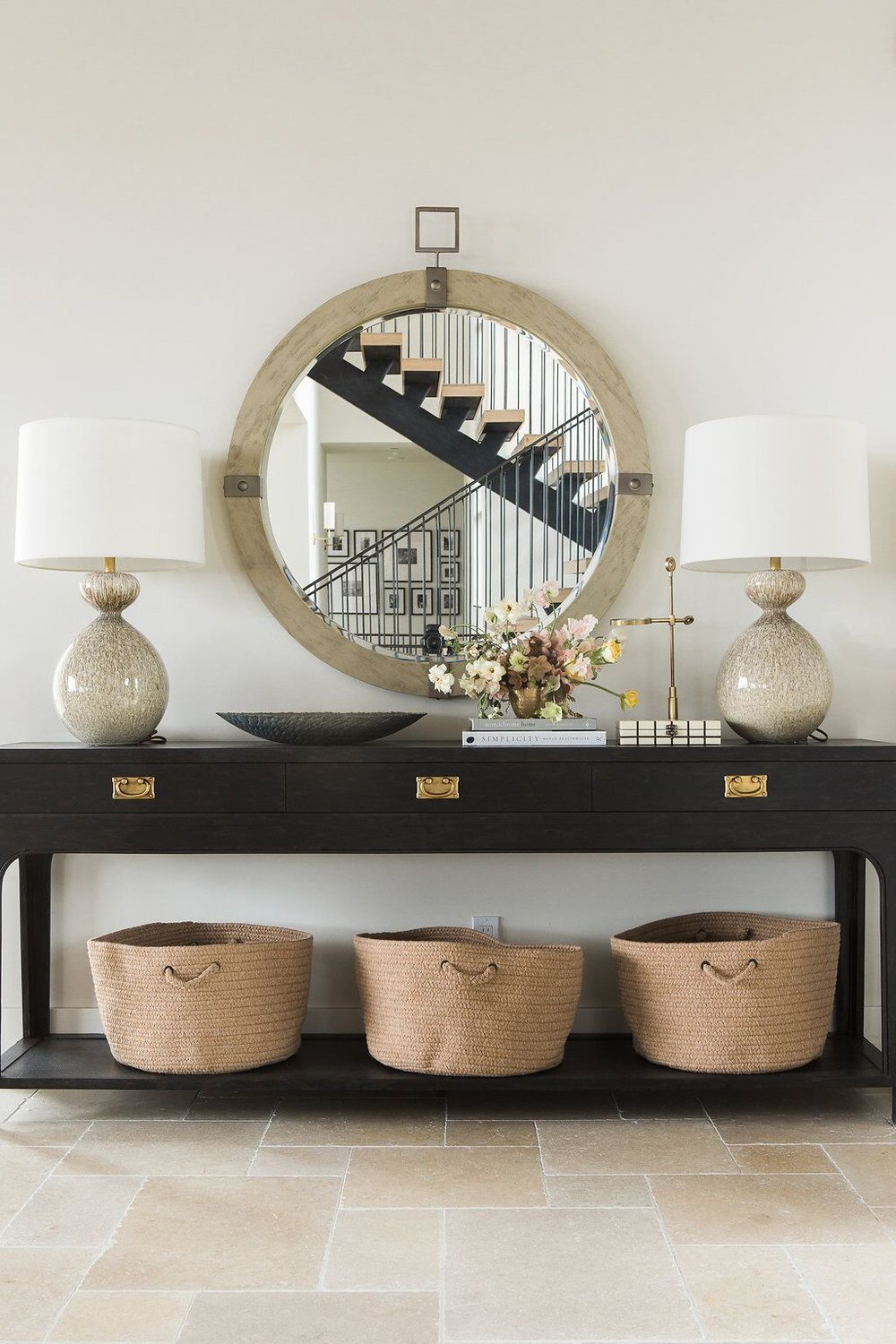 black console table with large mirror and two table lamps