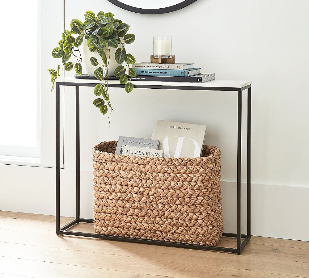 marble topped console table with trailing plant and basket underneath