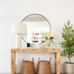 console table with large round mirror and baskets underneath