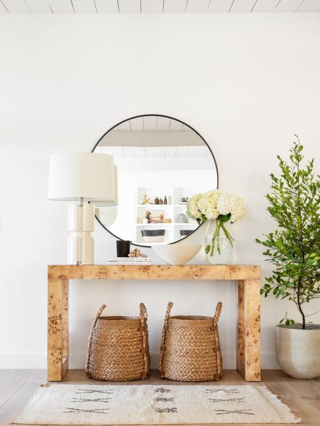 console table with large round mirror and baskets underneath