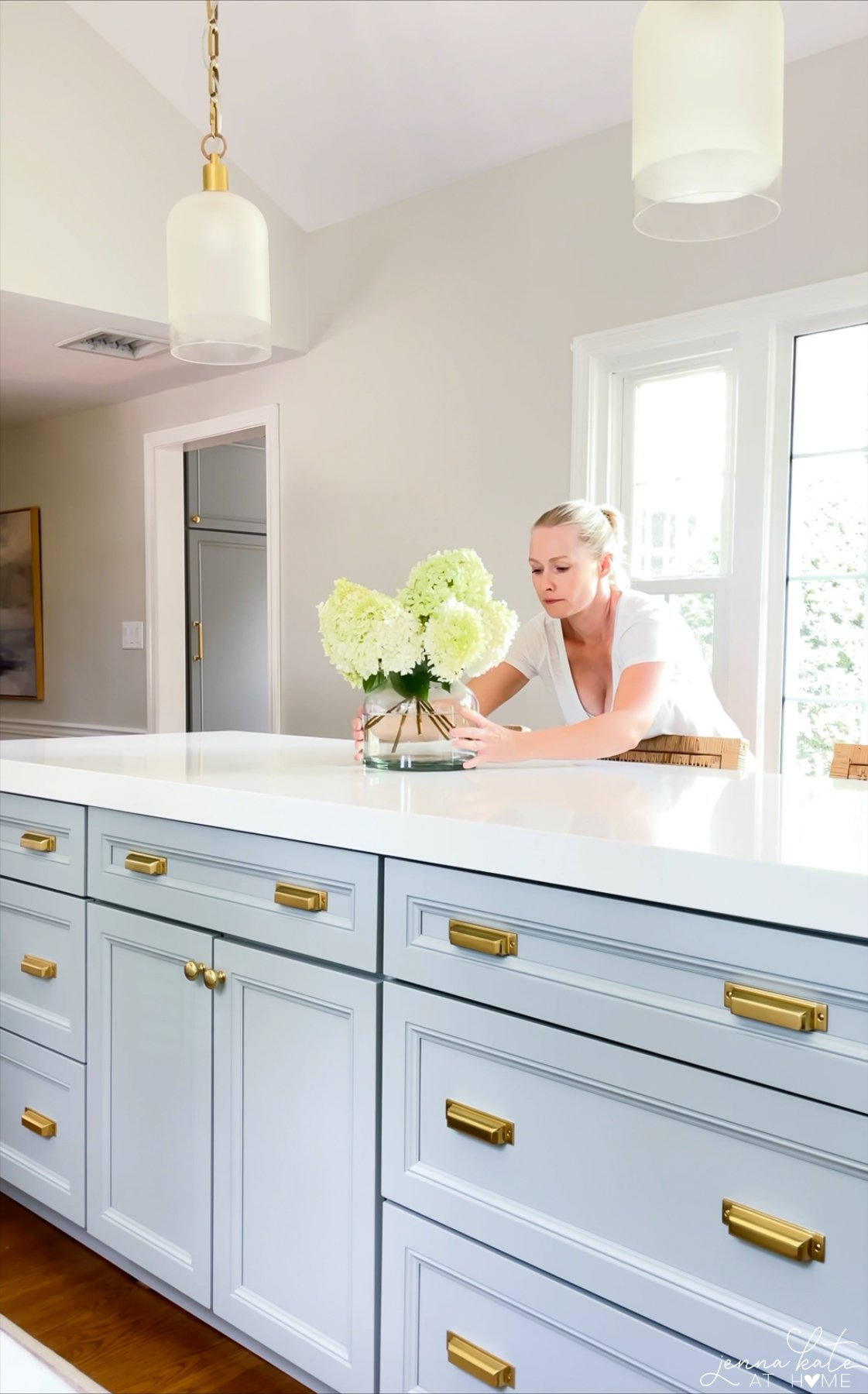 author putting vase of hydrangeas on a kitchen island