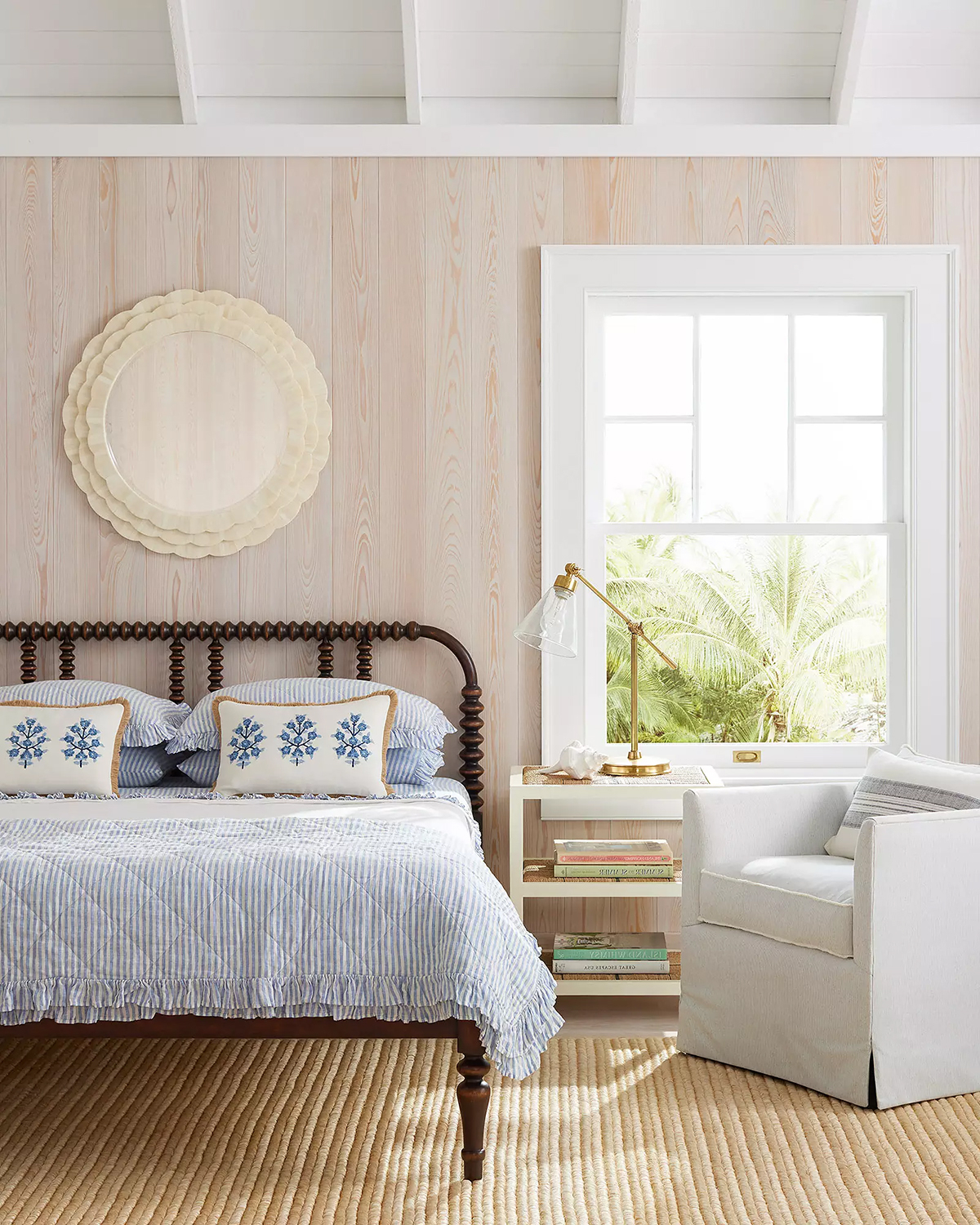 a round mirror hanging above a bed