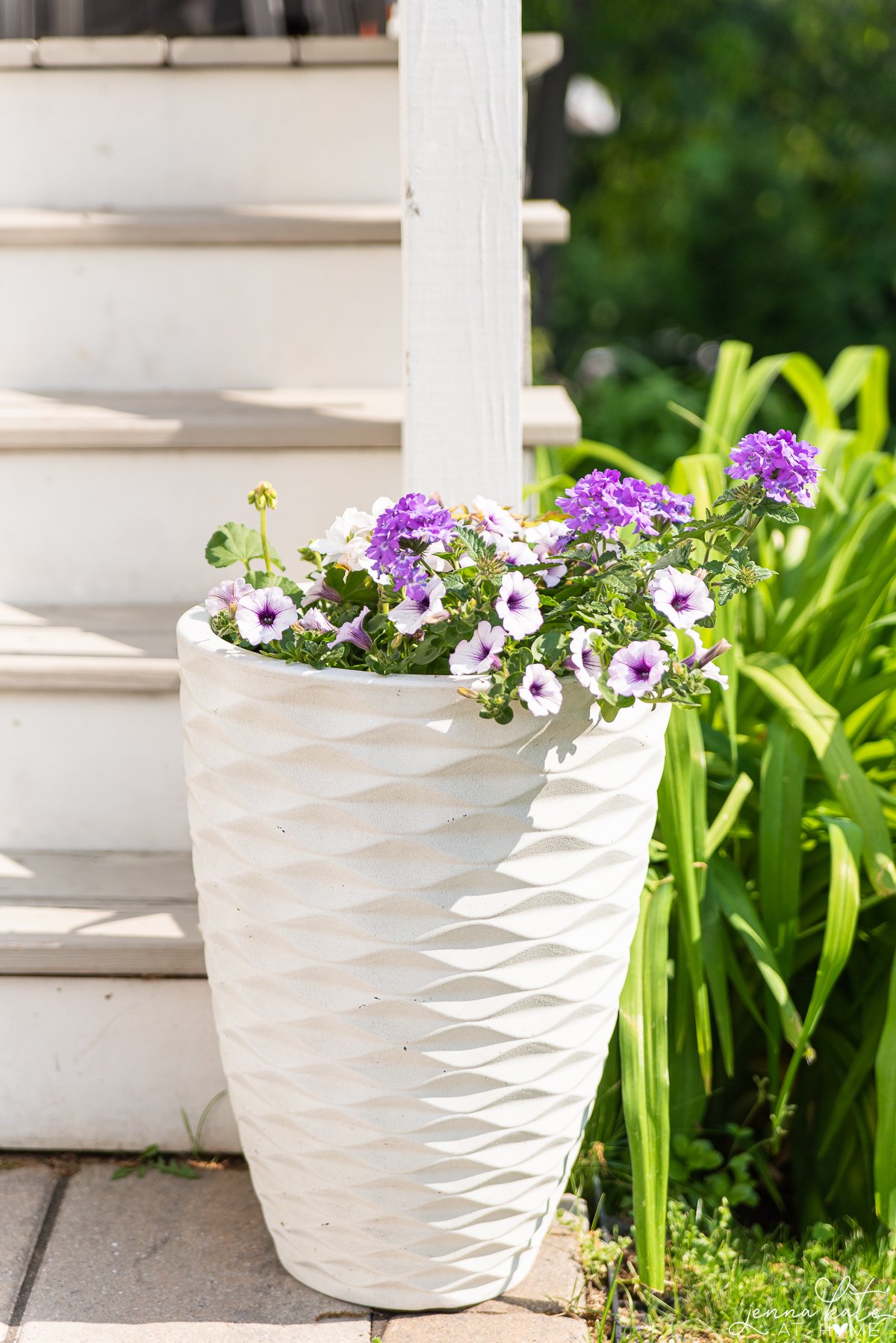 tall planter overflowing with purple petunias