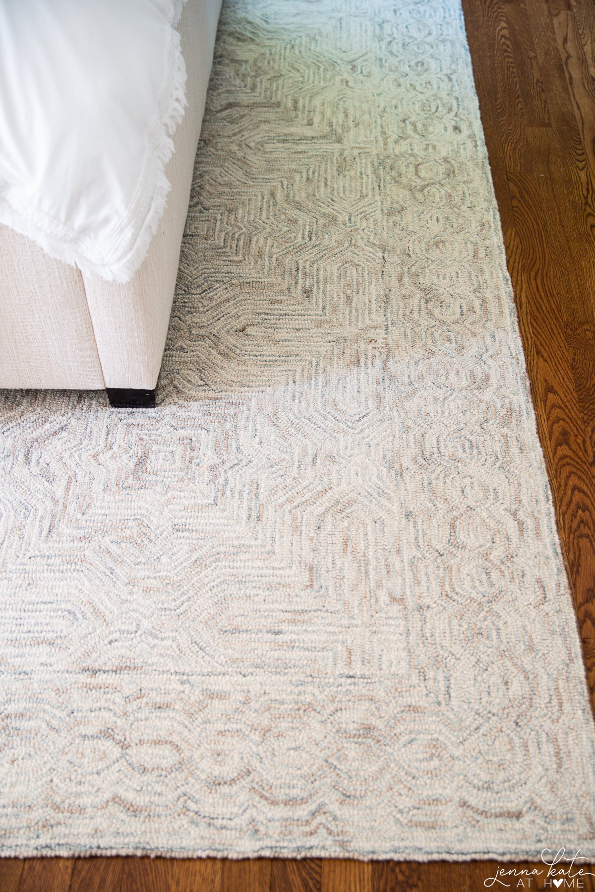 neutral bedroom rug on top of hardwood floors 
