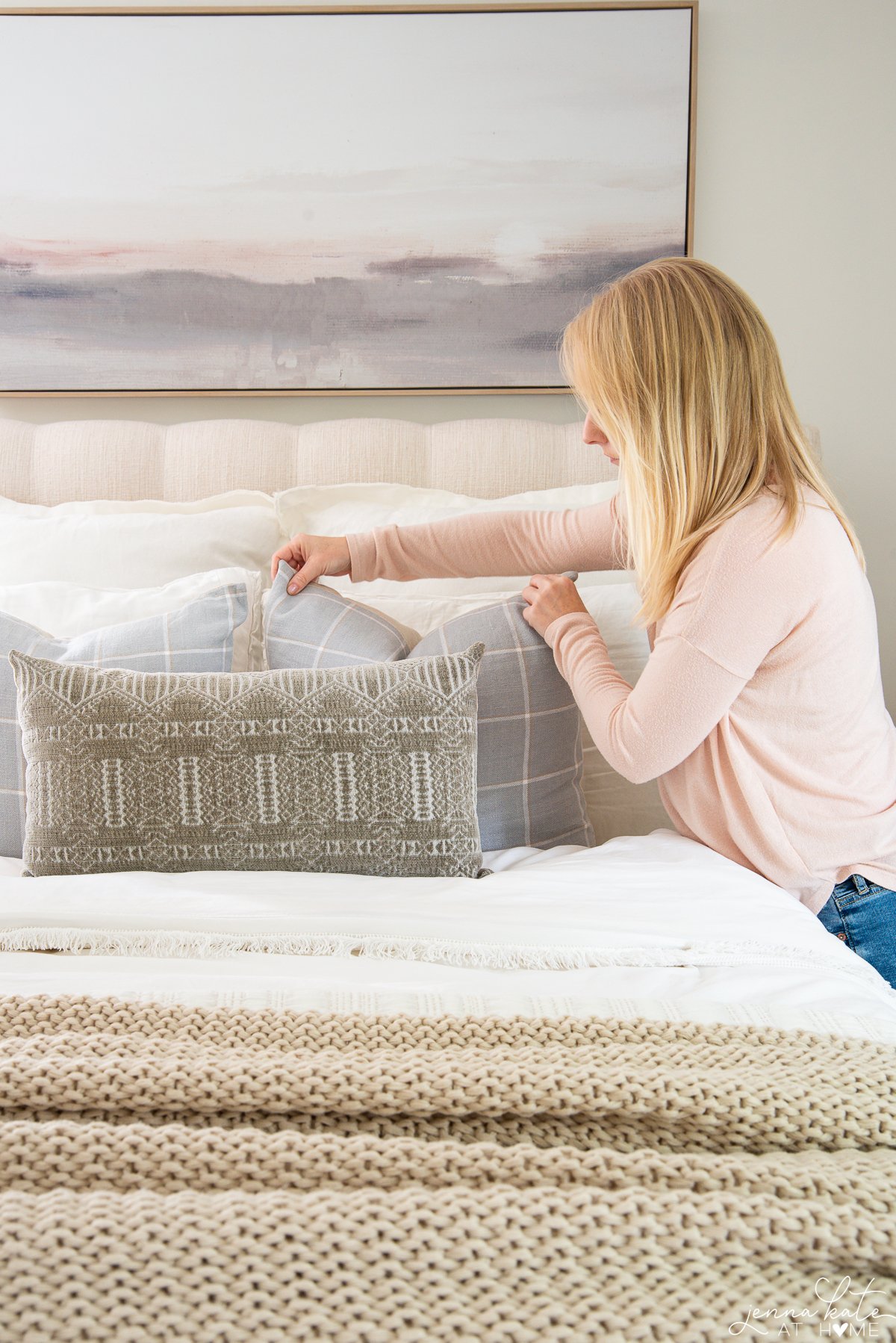 the author arranging pillows on the bed