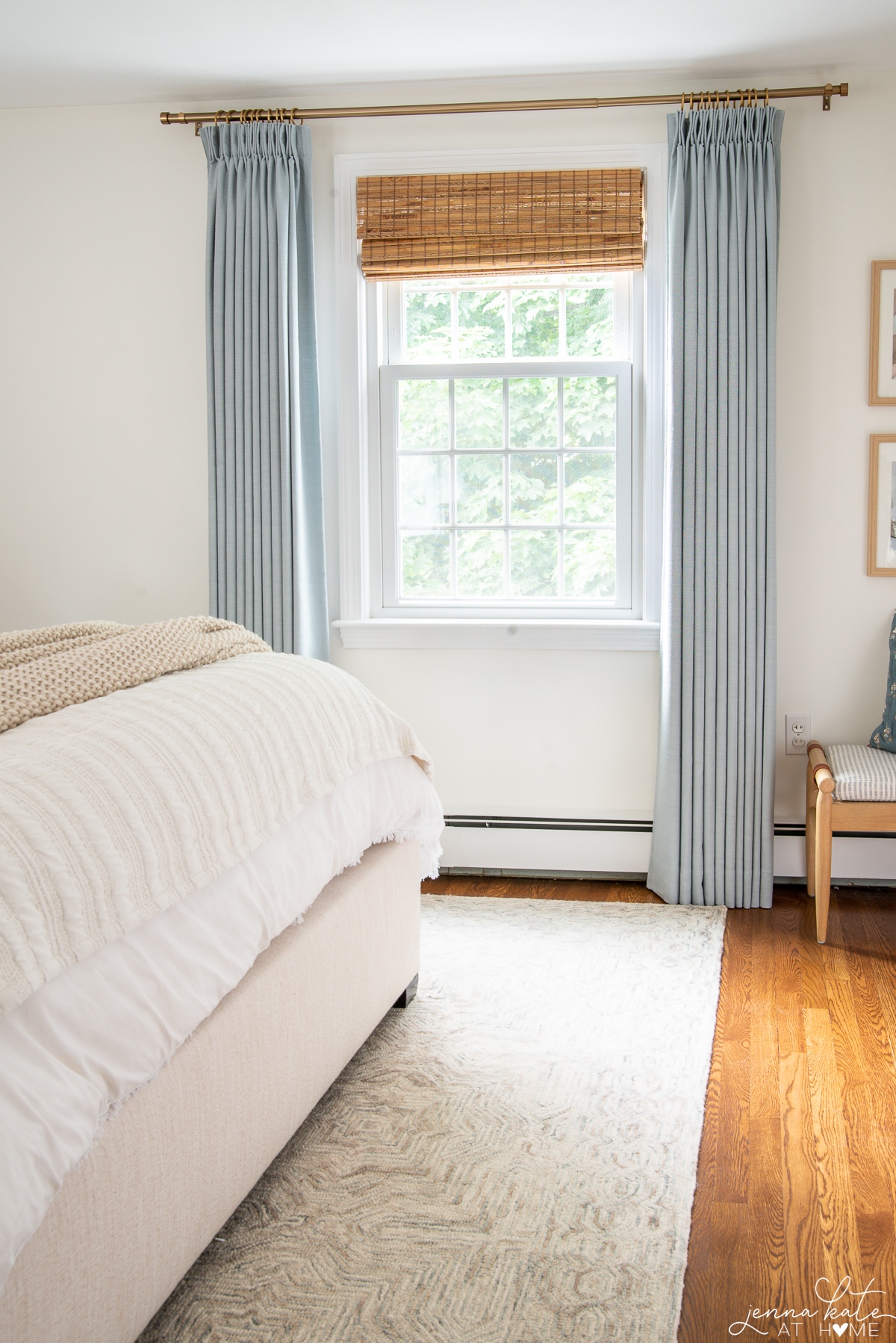 blue curtains with a bamboo shade and brass curtain rod