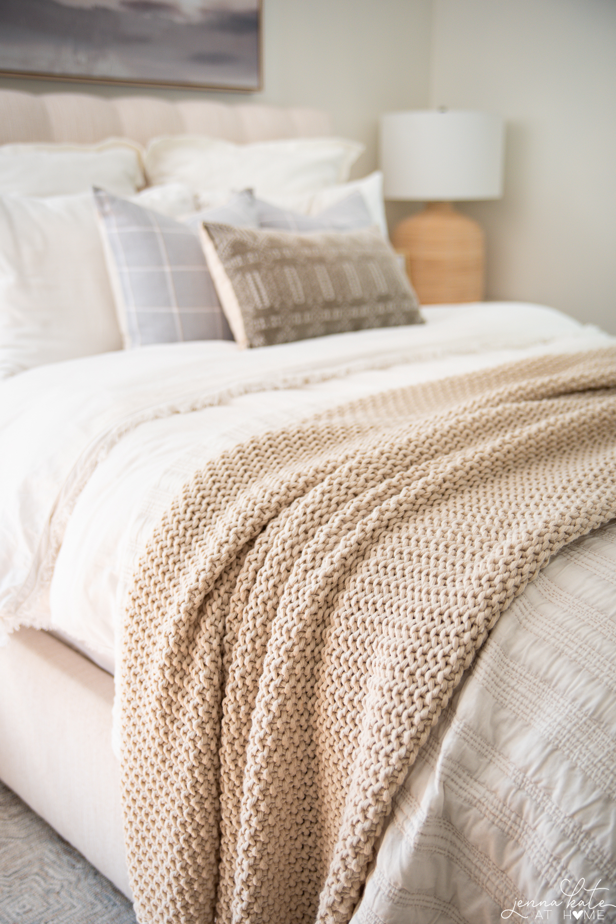 chunky knit blanket on the end of a bed.