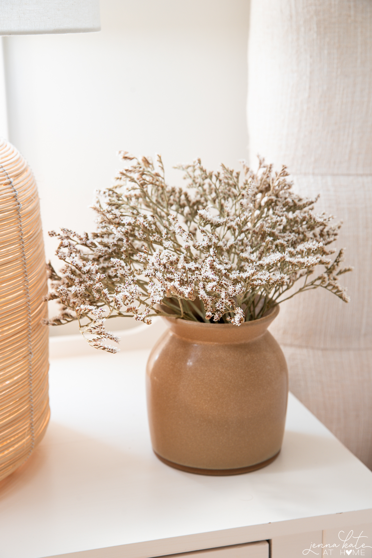 ochre colored vase with dried white flowers