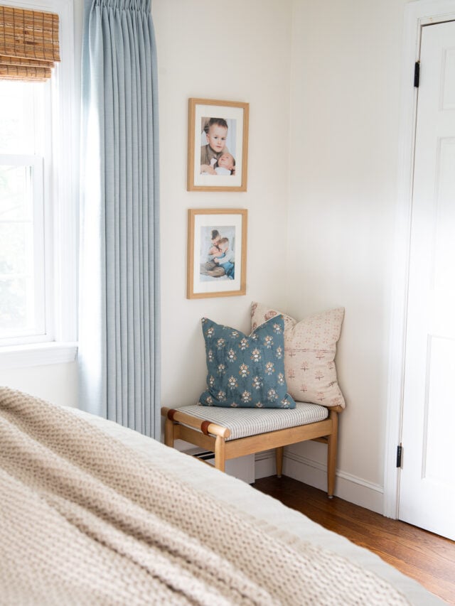 bedroom bench with contrasting throw pillows and white dove walls.