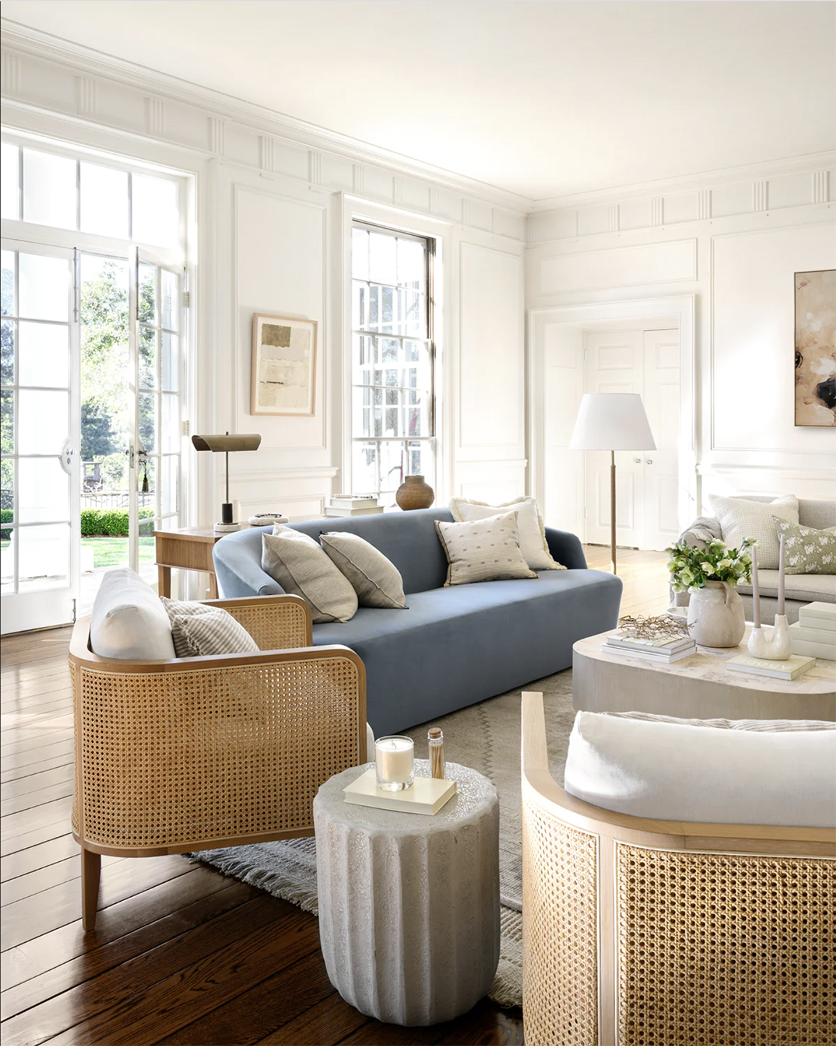 living room with cane accent chairs and a blue sofa