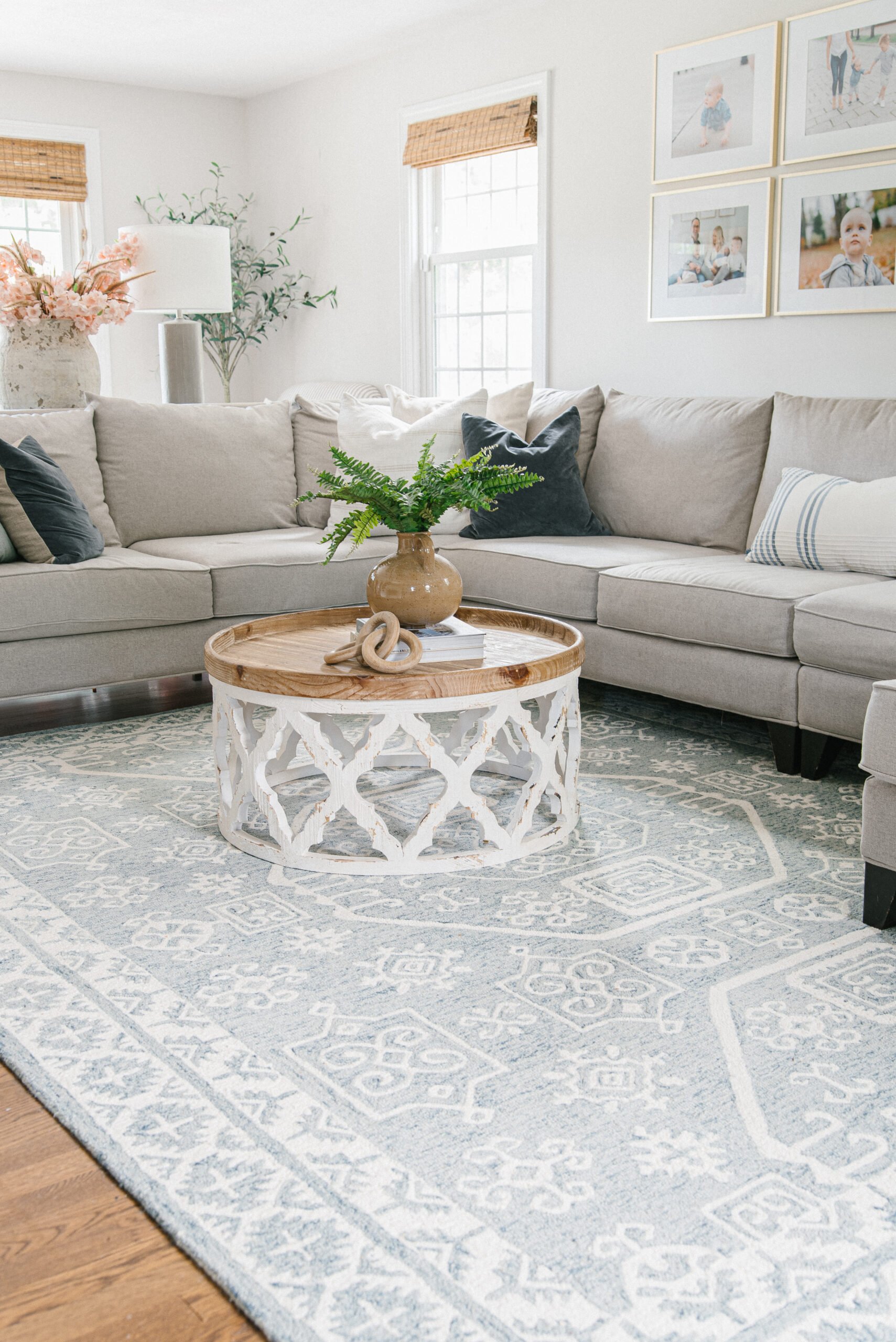 living room with sectional, blue rug and drum coffee table