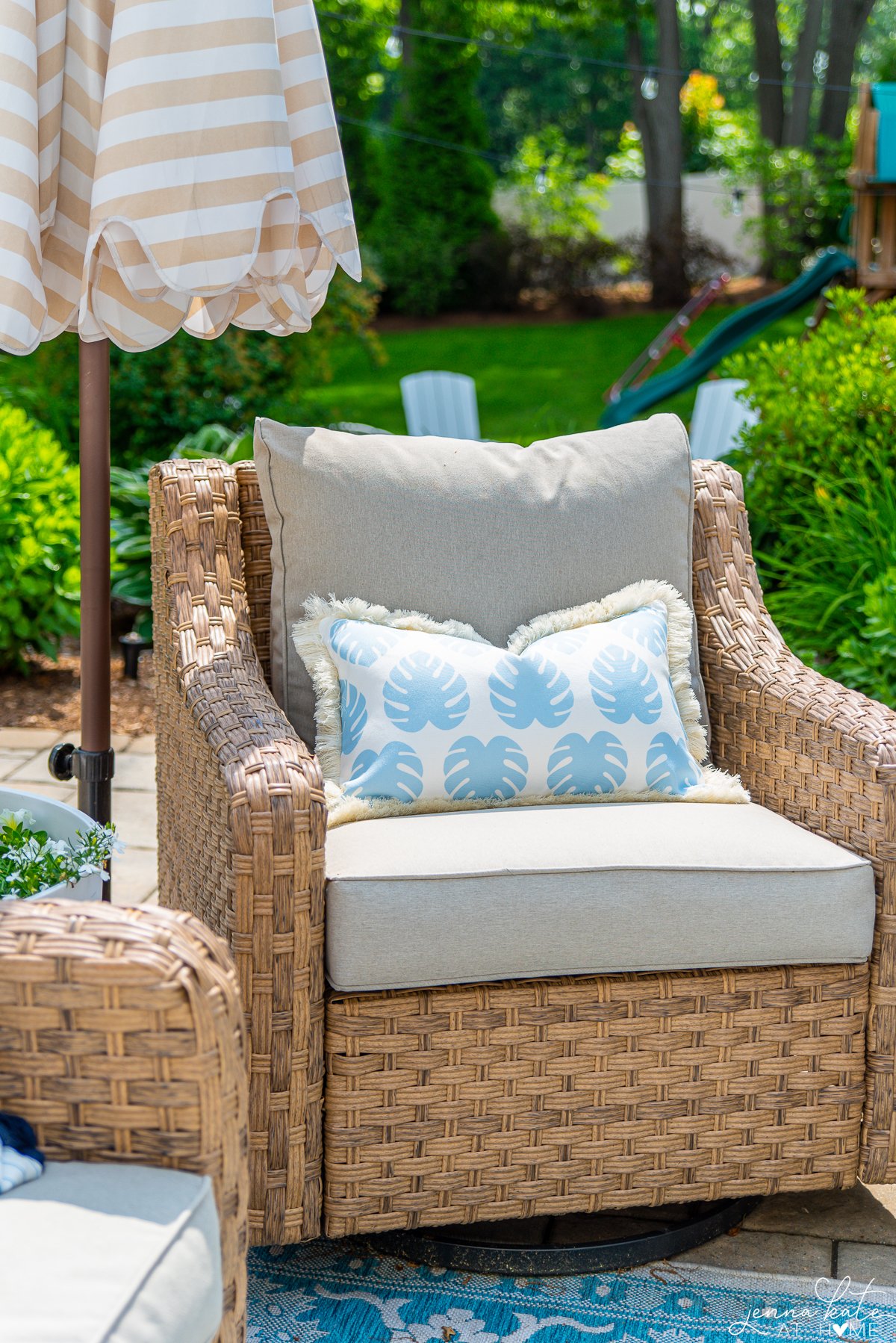 blue palm print lumbar pillow on a patio swivel chair