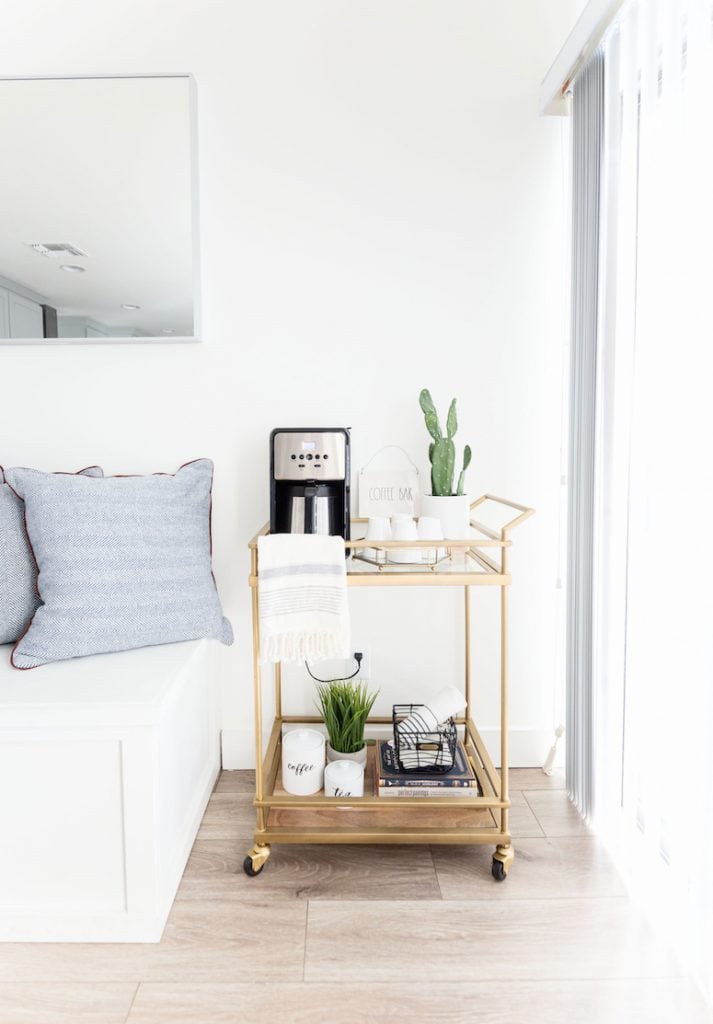 Bright room with a simple gold bar cart as a coffee station