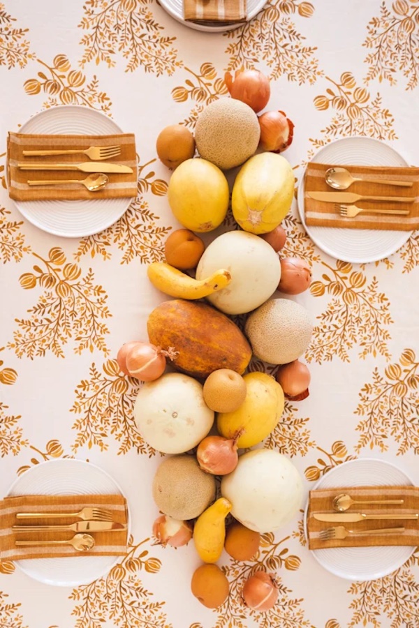 Thanksgiving table decor with orange and white color scheme and tons of matching produce