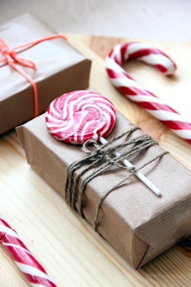 Simply wrapped Christmas gifts with a candy cane lollipop attached to each box.