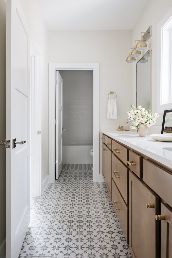 bathroom with patterned floor, wood vanity and classic gray walls